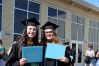 Graduates hold up their diplomas after the 2020 commencement