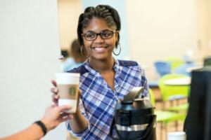 Student getting a coffee from the woods student center